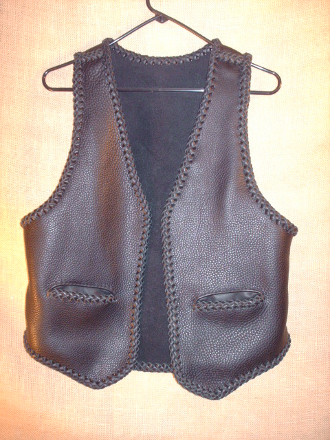  This black braided moccasin leather vest has slit hip pockets and a 3" draft flap at the back/bottom of it. 