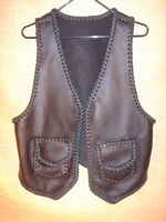  This braided moccasin cowhide leather vest has two front patch hip pockets with flaps ...which most always means that it also has two more matching pockets on the inside using the same braiding to attach it - that's four pockets in total. 