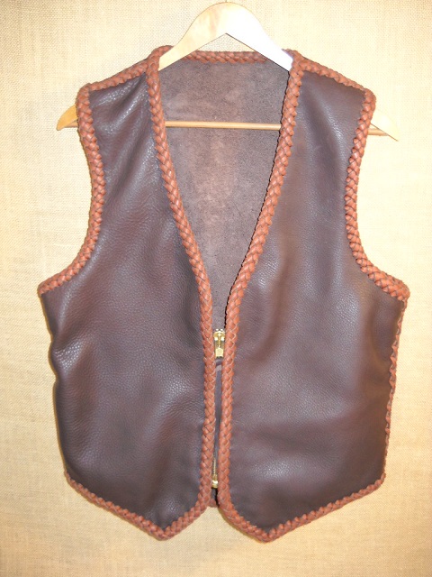  This two tone brown moccasin cowhide leather vest has the extended back/bottom draft flap and a (YKK #10) zipper closure. It also has inside panel pockets. 
