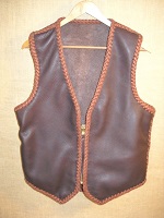  This two tone brown moccasin cowhide leather vest has the extended back/bottom draft flap and a (YKK #10) zipper closure. It also has inside panel pockets. Also pictured on the page linked to it is a zipper extension that I made for it. 