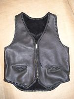  This black leather vest was built for a guy to use with his motorcycle. It features two hip slit pockets and a large (YKK #10) brass zipper. It also has, what I call, a back draft flap ...which is a 3" extension of the bottom/back. If you click on the link to this picture, you'll go to other better views of it's features. 