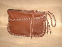  This picture is of a leather clutch purse constructed with 1/4" laces cut from the 4 oz. moccasin cowhide that it is made with. It is braided around its seam, across the front pocket, and its strap with tassels. The large zippered closure is hand sewn with 5 ply nylon thread and has a long strap fastened to its tab/slider. 