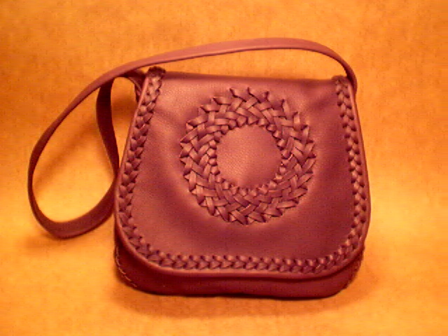  Another braided leather handbag with a cicle applique on the flap. The one is made with my Mahogany colored leather. It has a full width pocket on the inside/back of it. 