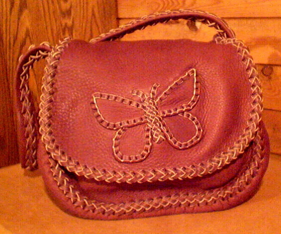  This picture is of one of the custom handmade leather purses that I make. No electricity is used in this construction. Every seam, the edges of the flap, down the center/length of the strap, etc. are all braided with 1/4" wide laces of 4 oz. moccasin cowhide leather. It's 100% leather - it has no hardware, no lining or thread. 