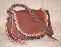  This picture is not a picture of the similar purse to the left. While they are both made using Mahogany parts, and the same two colors are used for the braiding. However, the locations of of those two colors in the braiding are all different. And, this one doesn't have the Walnut colored tassels that the other one has a few of. 