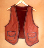  This two tone brown handmade leather vest was custom made in the USA with moccasin cowhide leather that is tanned in the USA. It has patch hip pockets with flaps and, on the inside, it has matching pockets without flaps. 