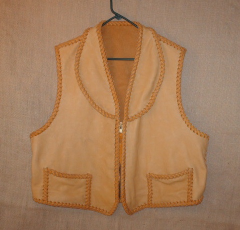 This custom leather vest was fashioned after a vest that the buyer sent me. He also sent me the Elk skin to make it with. I decided to use my moccasin cowhide laces as that would make for a stronger vest. It has a shawl collar, two low hip pockets with two more matching hip pockets on the inside (four pockets in total). 