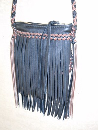  This small Black purse with fringe has a round strap and a large brass zipper across the top of it. It measures about 8" wide by 8" high. This purse has braided seams and a braided strap, both employing 1/4" wide (Black and Mahogany) laces. 