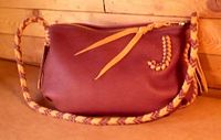 This small bag has a Mahogany colored leather body and a zipper closure. The braided seams and strap were done with Mahogany and Chestnut colored leather ...as is the 'J' applique on the side of it. 