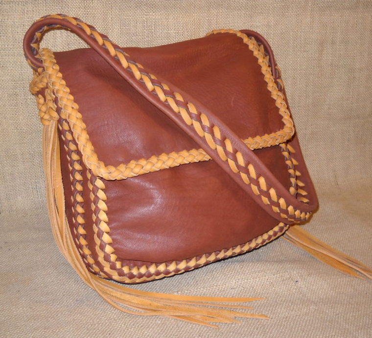  This Mahogany colored bag employs two tones of laces for it's braiding - Mahogany and Chestnut. All of it's seams are braided, there's braiding around it's flap, there's a braid down the center/length of it's strap that is attached with braiding that includes very long Chestnut tassels. 