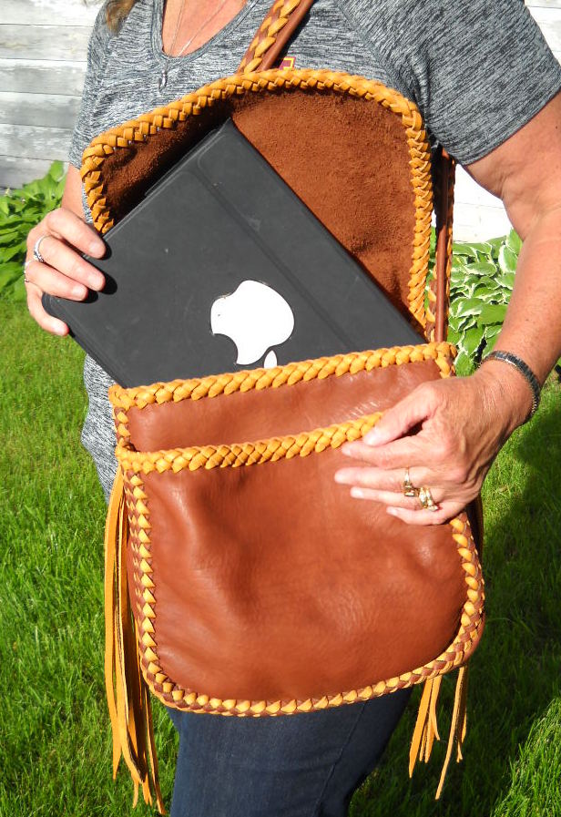  This picture of this style of bag shows that it has two compartments under the flap, and, it shows an Ipad slipping into a back pocket of the back compartment. 