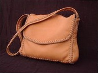  The dimensions of this large Chestnut colored moccasin cowhide leather bag are about 12.5" high x 11" high x 3". It has a full width pocket on the front under the flap, and a pocket on each side. It also has a large full width pocket on the inside/back. It is completely handmade - no electricity is used in it's construction.  