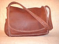  Here are two views of a large Mahogany colored leather bag. It's about 14.5" wide by 12" high by 4" and has the two side pockets, a full width pocket under the flap, and another full width pocket on the inside/back. 