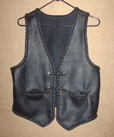  This moccasin cowhide leather vest has all of it's edges and seams braided. It has two slit hip pockets (with braiding) and two sets of 'trick braided' snap closures. It's all hand braided and made in the USA using leather that was tanned in the USA 