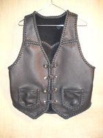  This black moccasin cowhide leather vest has slanted front yokes, a pointed back yoke, two patch hip pockets (without flaps), and four sets of 'trick braided' leather snaps for closures. It also has a draft flap that has become popular with my customers. This draft flap is a 3" extension of the back/bottom that can better be seen on the page that this picture is linked to. 