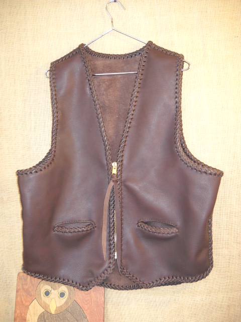  This Brown leather vest, whose seams and edges are completely braided. It has two slit hip pockets, a brass (YKK #10) zipper closure, and what I call a draft flap at the bottom of the back. 