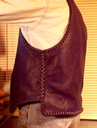  This black leather vest was made to be worn over a motorcycle jacket. I do that by making some adjustment to its chest size, arm hole size, etc. This vest also has, what I call, a 3" draft flap at the back/bottom of it. It also has the two sets of brass snaps and D rings for closures. There are more pictures of these features on the page this picture is linked to. 