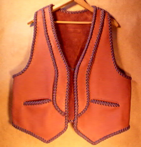  This two tone moccasin cowhide leather vest has rather uniques lapels and back yoke on it - the back yoke can be better seen by going to the page the picture is linked to. It also has the two slanted slit pockets. 