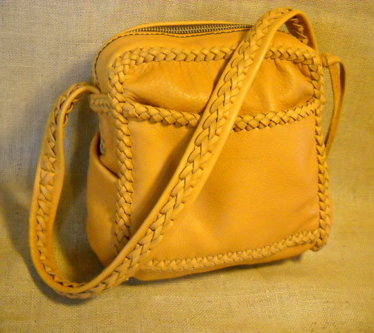  Another handmade custom leather purse. This one is about 10" wide by 11" high by 3". It has four pockets and a braided strap. Something different about it than most others I've made ...the front pocket is braided across the top of it.