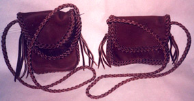  These two small leather purses are completely braided. One is about 7" high by 4" wide ...and the other is about 7" wide by 4" high. Both have 4 strand braided shoulder straps with tassels on their ends. 