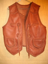 Here is a western style braided vest using moccasin cowhide leather. It has pointed front yokes, a pointed back yoke, two patch hip pockets with flaps, ans two breast pockets (credit card size). It also has straps hanging from a concho I fashion with a braided circle. 